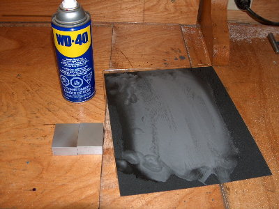 Pick the best side of each block, and wet sand it using the sandpaper on the piece of glass. Keep it wet with the WD-40.