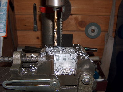 Now we need to CAREFULLY line the blocks up and secure them in the vise. One on top of the other. Drill through both blocks as shown so that they can be bolted together. Use WD-40 as cutting fluid. Keep the bit and the end of the hole wet.
