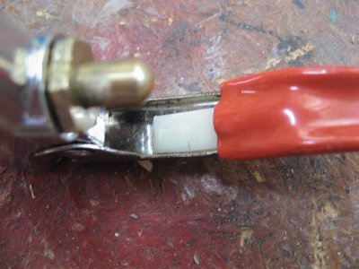 Piece of plastic I found in the garage. Anything hard, that wont compress, will do. This plastic is about 3mm thick