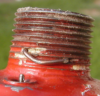 A welding rod was bent and the ends pushed into a pair of holes.  There are no sharp points outside.  Yes the piston end rests this far forward for a small dead space.