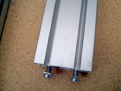 Tapped end with screws. You don't screw through the opposed member, you slide the screw heads into the slots and then use the holes in the other member to get the Allen key in place. It means the system is infinitely adjustable to get everything square.