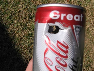 Hammer round passed through the can but the tail stayed in the can. Can was filled with water.
