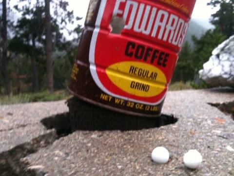Coffee can full of water after being shot. Marble was stopped at other end, leaving a dent. Found powdered marble in the bottom.