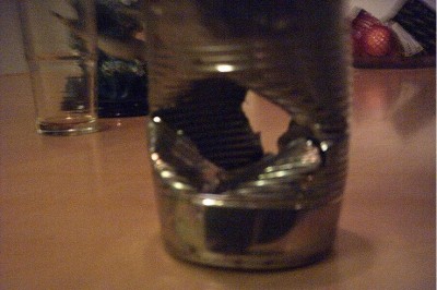 First some damage to a steel can.The entry hole runs from one side to the other.Viewed from the front it nearly cuts the can in half.The exit hole is smaller but looks much more jagged.Bent the entire can out of shape.