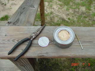 When you are done punching the holes take the cutout out with the pliers.Next empty and clean the can of all tuna.