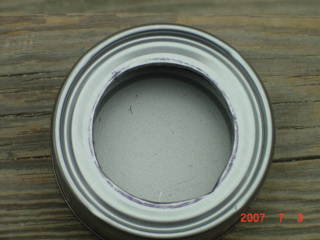 After rolling the edge of the tuna can it should now be smooth.The inner can should fit very tightly in this hole.The tighter the better for a seal.Check often to make sure the hole isn't too big.Continue until the can fits perfectly.